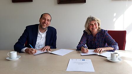 Op deze afbeelding: Frank van der Jagt, directeur van MENS De Bilt, en wethouder Madeleine Bakker ondertekenen de samenwerkingsovereenkomst.